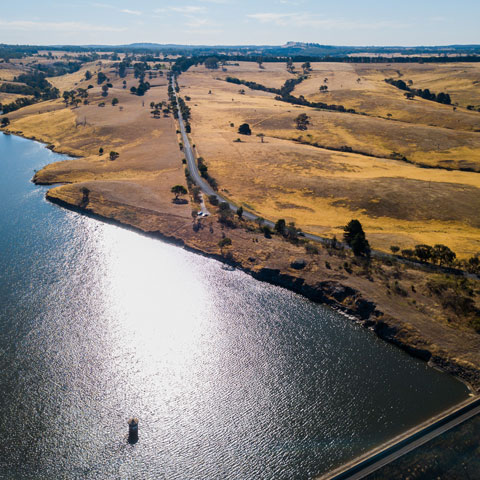 Aerial view over the Upper Coliban Reservoir dam wall, including inlet tower of Coliban dam.