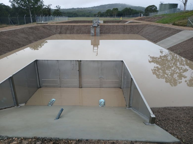 Lagoon filled with water and a second lagoon and new bore tank in the background.