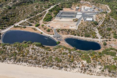 Aerial view of a wastewater treatment plant and surrounding landscape. 