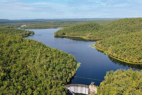 Aerial view of Manton Dam with dam wall in foreground and green bushland surrounding the dam.