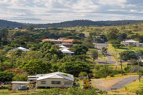 View of the leafy town Mount Morgan with mountains in the background.  