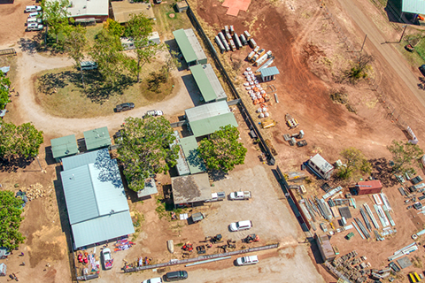 Aerial view of the community of Kalkaringi, Northern Territory, showing housing and parked cars in a desert area.