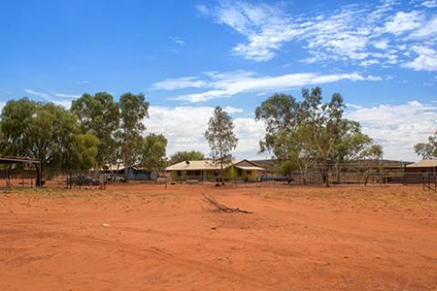 Australian desert and corrugated iron buildings in the background.